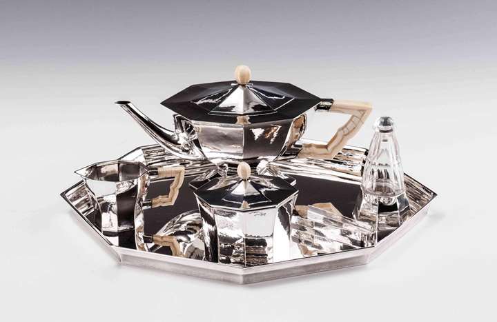 SILVER TEA SERVICE
consisting of: teapot, creamer, covered sugar bowl, sugar tongs, rum flacon, tray
